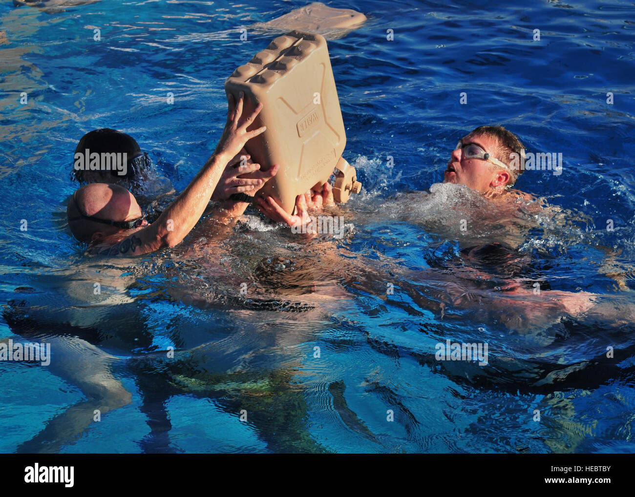 Members from 26th Special Tactics Squadron rally together to empty a five gallon jug while treading water during the pool component of a Monster Mash Aug. 6, 2014, at Cannon Air Force Base, N.M. The Air Commandos were memorializing the sacrifices of those who lost their lives aboard Extortion 17. (U.S. Air Force photo/Staff Sgt. Alexxis Pons Abascal) Stock Photo