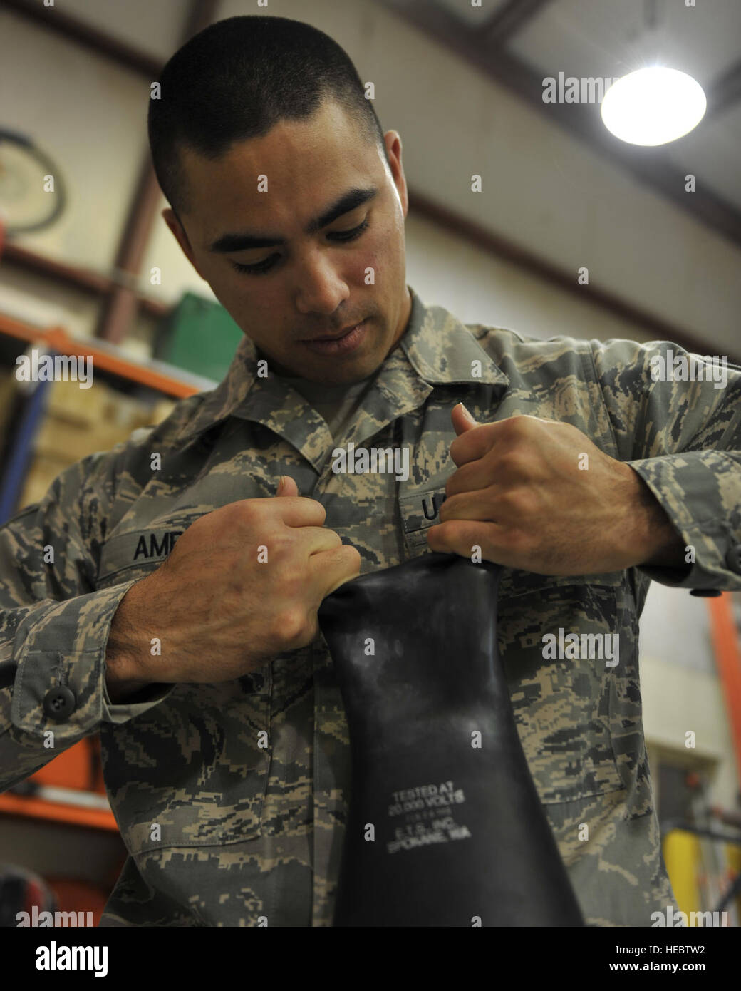 Staff Sgt. Joshua Amby performs a visual glove inspection at the 379th Air Expeditionary Wing, Southwest Asia, Dec. 30, 2013. Amby has tested 62 pairs of gloves since Dec. 23. Testing is a requirement for all gloves received and in current inventory. Gloves used daily are tested every six months or sooner if a glove is turned in for inspection. Amby is a 379th Expeditionary Civil Engineer Squadron electrical systems craftsman deployed from Ramstein Air Base, Germany and a Lanai City, Hawaii native. (U.S. Air Force photo by Master Sgt. David Miller) Stock Photo