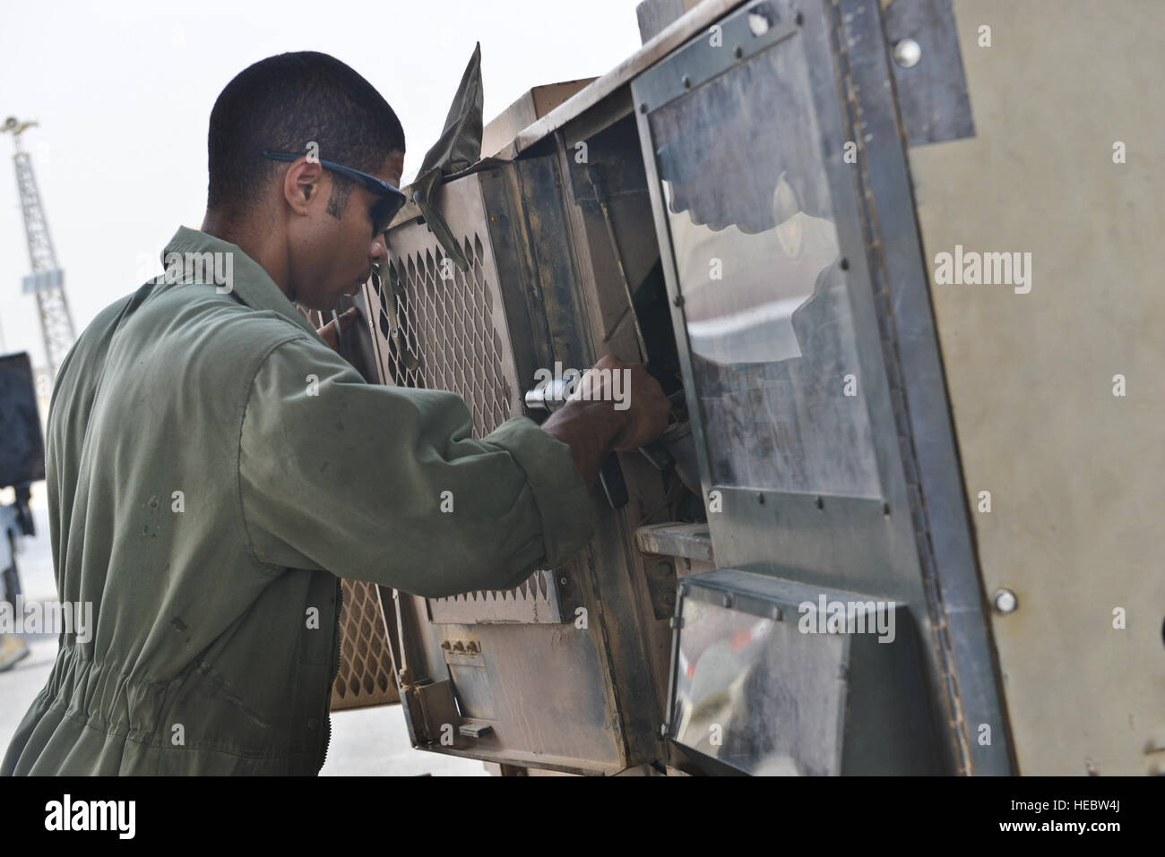 Senior Airman Udoka Addy, 379th Expeditionary Maintenance Squadron, applies rivets to a generator door during routine aerospace ground equipment repairs May 7, 2015 at Al Udeid Air Base, Qatar. Aircraft ground equipment airmen rotate shifts to ensure day and night operations are supplied with functioning equipment. These airmen endure heat that sometimes reaches above 100 degrees Fahrenheit causing them to sometimes work in black flag conditions. (U.S. Air Force photo by Staff Sgt. Alexandre Montes) Stock Photo