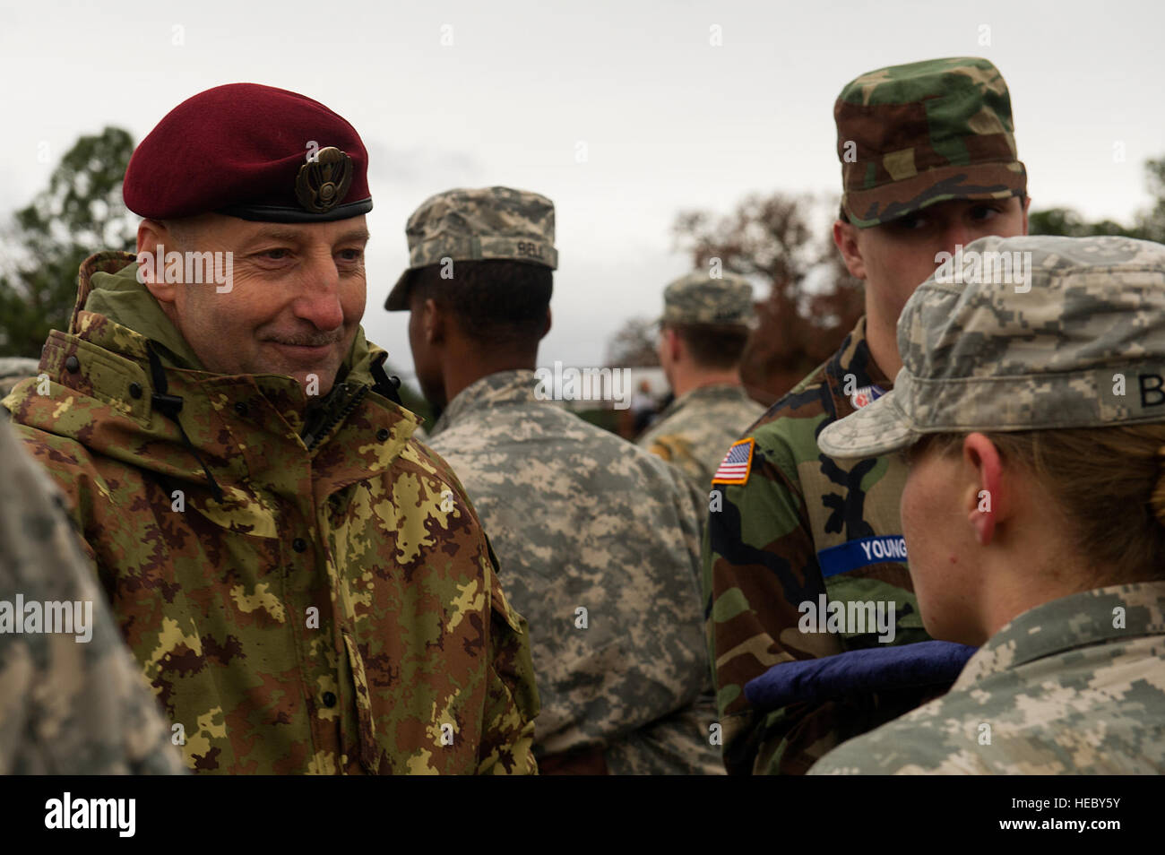 Cpl. Mauro Alasia, Italian Army paratrooper, pins on Italian jump wings to U.S. Army paratroopers after following the command of the Italian jumpmasters, Fort Bragg, N.C., Dec. 7, 2013. The 16th Annual Randy Oler Operation Toy Drop, hosted by the U.S. army Civil Affairs & Psychological Operations Command (Airborne), is the largest combined airborne operation in the world where Fort Bragg's paratroopers and allied jumpmasters donate toys to be distributed to children's homes and social service agencies across the local community.  (U.S. Air Force photo by Airman 1st Class Logan Brandt) Stock Photo