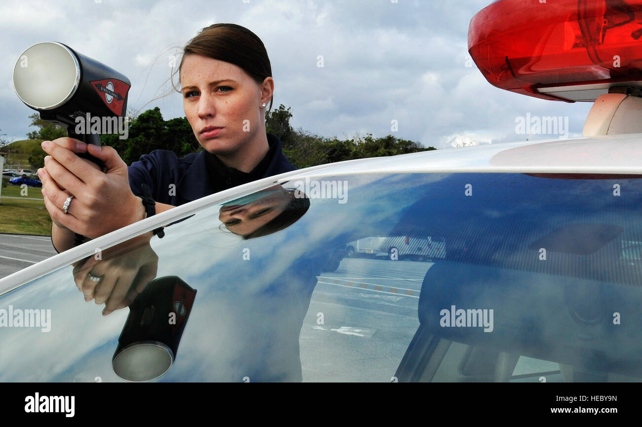 Senior Airman Sarah Oswald uses a speed-detecting radar gun to measure how fast cars are going during a daily traffic control Jan. 10, 2014, at Kadena Air Base, Japan. Members of the 18th Security Forces Squadron conduct traffic controls every day along with Japanese civilian guards, using radar to detect speeding vehicles. Oswald is an 18th SFS patrolman. (U.S. Air Force photo/Naoto Anazawa) Stock Photo