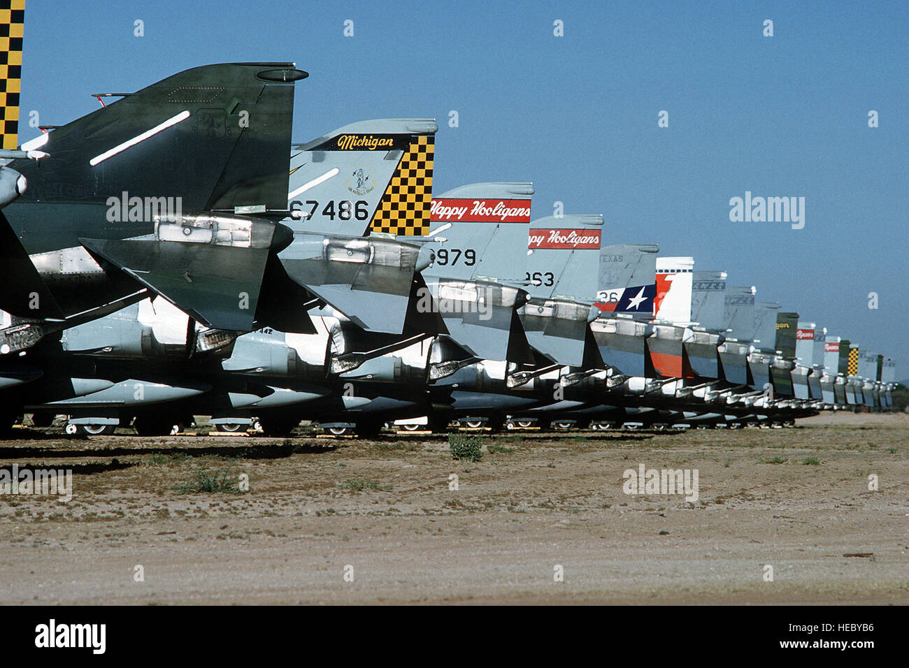 The tail fins of a line of F-4D Phantom II aircraft depict markings from Air National Guard units of Michigan, North Dakota, Texas, Kansas and Oregon.  The Phantoms are parked in line at the Aerospace Maintenance Regeneration Center, where stored planes that have been removed from service are either sold for scrap, returned to the inventory, or sent to museums. Stock Photo