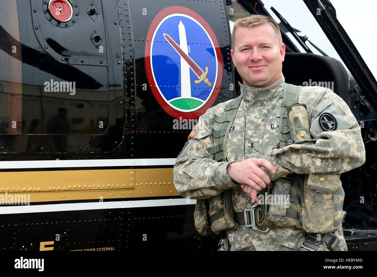 U.S. Army Chief Warrant Officer 2 Michael Beck, Charlie Company, 12th Aviation Battalion pilot, stands in front of a VH-60 Black Hawk helicopter after its final flight to Fort Eustis, Va., March 10, 2015. The retired helicopter was used as a form of transportation for VIPs, including the chairman of the Joint Chiefs of Staff, and is set to become a display at the U.S. Army Transportation Museum. (U.S. Air Force photo by Senior Airman Kimberly Nagle/Released) Stock Photo