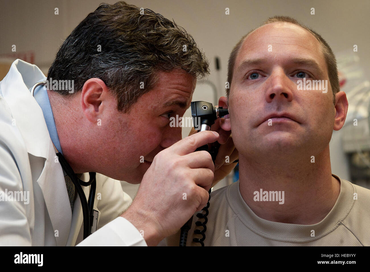 Sean Harap, Tripler Army Medical Center physician, performs a physical exam for U.S. Air Force Capt. Joshua Gscheidmeier, 128th Air Refueling Wing, at Tripler Army Medical Center May 8, 2014, in Honolulu. The Nurse Advice Line is set to offer TRICARE beneficiaries an alternative to getting medical care starting May 30. The advice line is designed to offer patients a way to receive medical assessment, information, direction and care before choosing whether or not visiting an emergency room is necessary. (U.S. Air Force photo by Staff Sgt. Christopher Hubenthal) Stock Photo