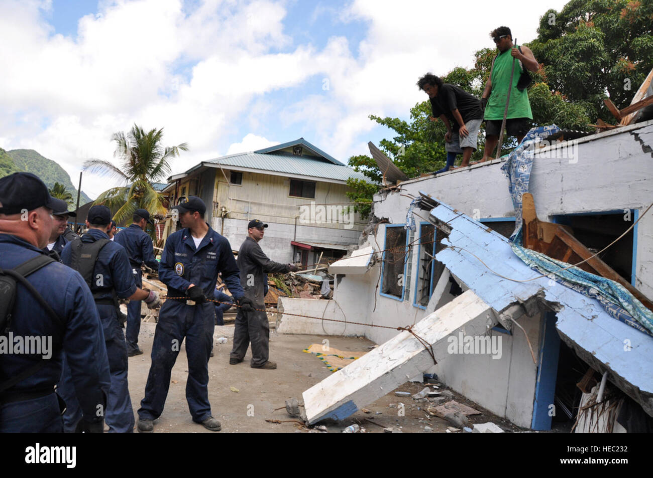 PAGO PAGO -  U. S. Navy Sailors from the U.S.S. Ingram prepare to pull down the remaining part of a roof from a home in the downtown area of Pago Pago, American Samoa on Oct. 3, 2009 after an earthquake and a tsunami left the the home and many others in ruins. (U.S.  Air Force photo/Tech Sgt. Cohen A. Young) Stock Photo