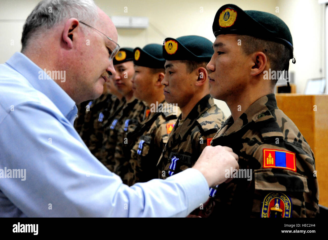 United States Ambassador to Mongolia Jonathan Addleton pins a NATO medal onto a Mongolian counterinsurgency trainer during his visit to Camp Julien, Afghanistan March 22, 2011. Ambassador Addleton visited Afghanistan to extend his thanks and gratitude to members of the Mongolian Army for their contributions to the NATO Training Mission – Afghanistan goal which is to support the Government of the Islamic Republic of Afghanistan as it generates and sustains the Afghan National Security Force, develops leaders, and establishes enduring institutional capacity to enable accountable Afghan-led secur Stock Photo