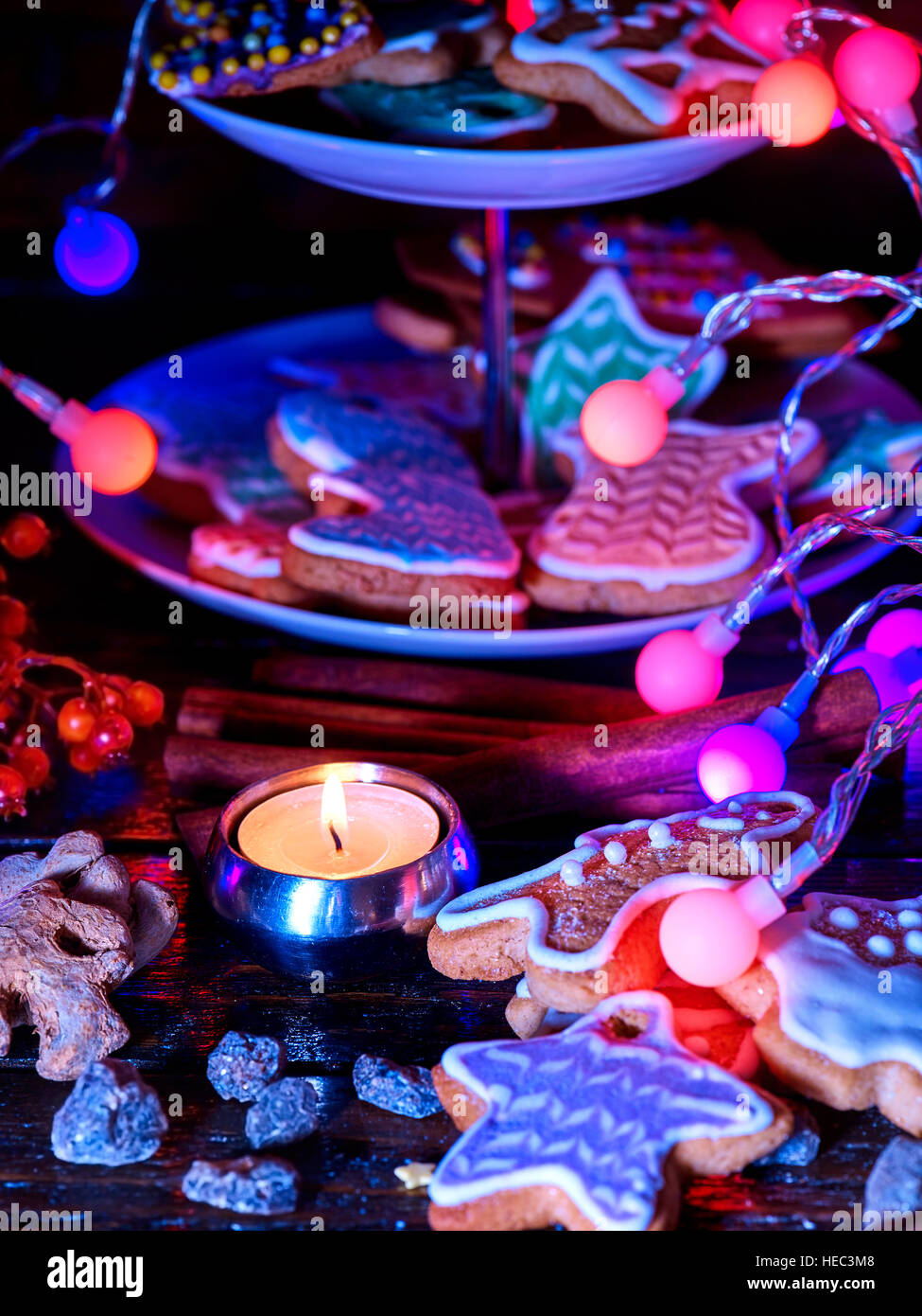 Gingerbread man on tiered cake. Food decoration christmas lights string. Stock Photo