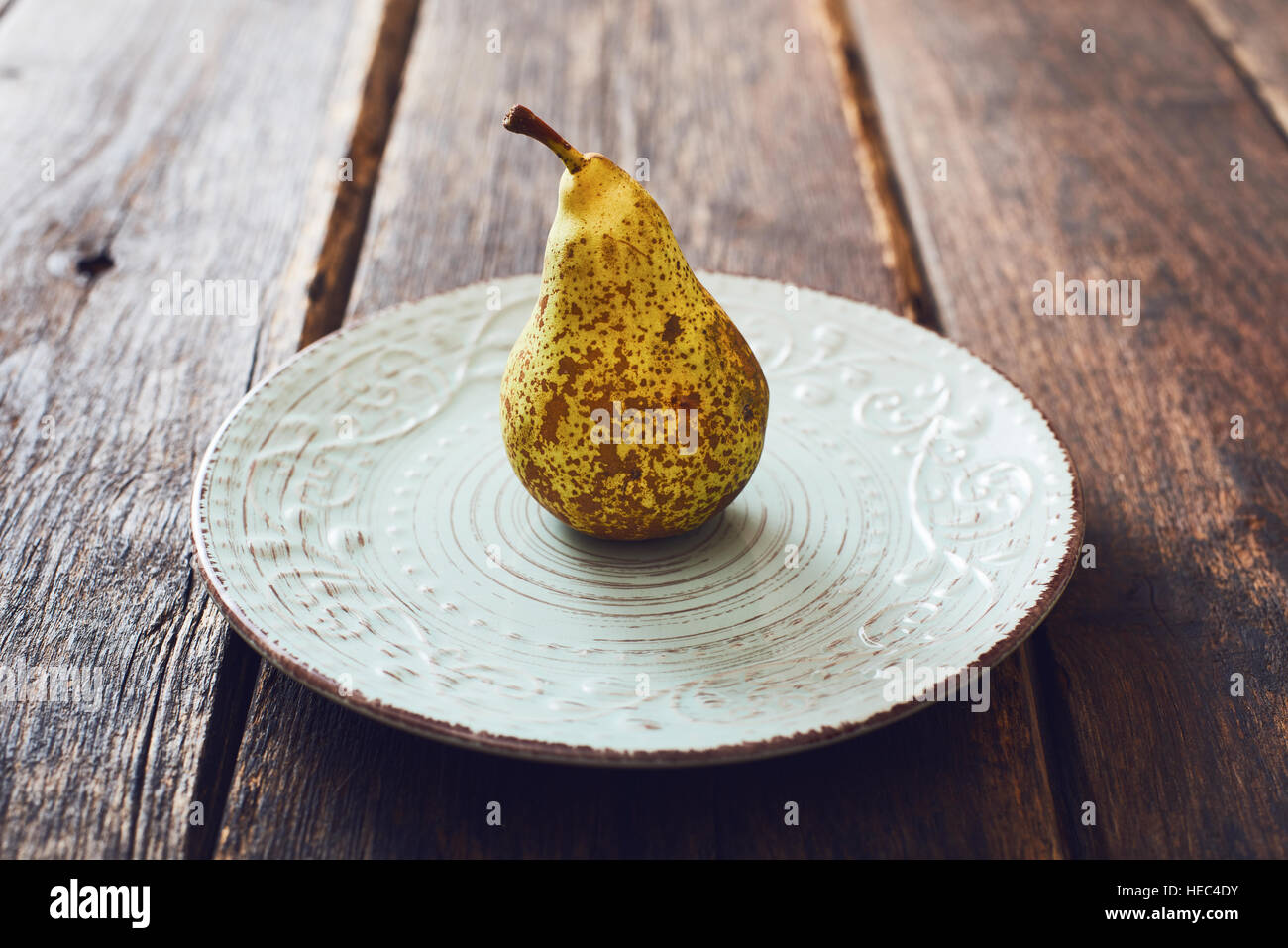 Pear on vintage dish and wooden table Stock Photo