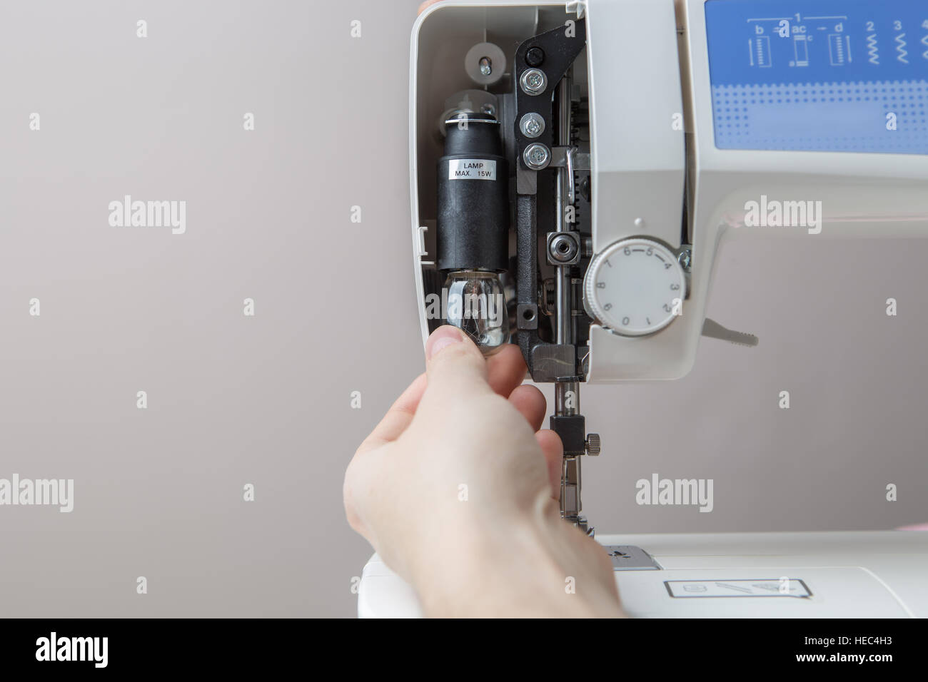 Young man mending sewing machine Stock Photo