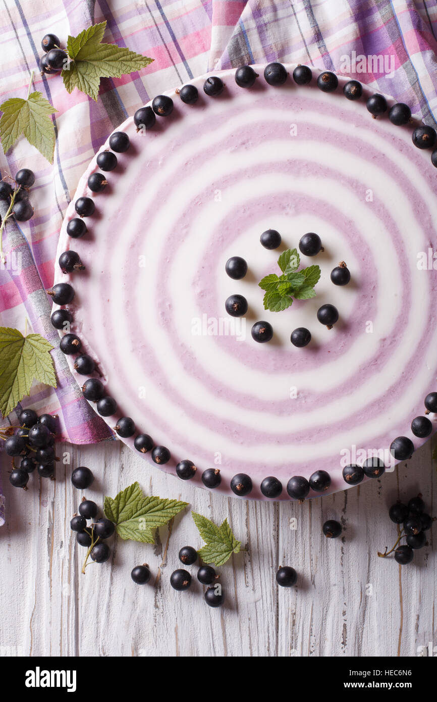 Delicious cheesecake striped black currant close up on the table. vertical top view Stock Photo