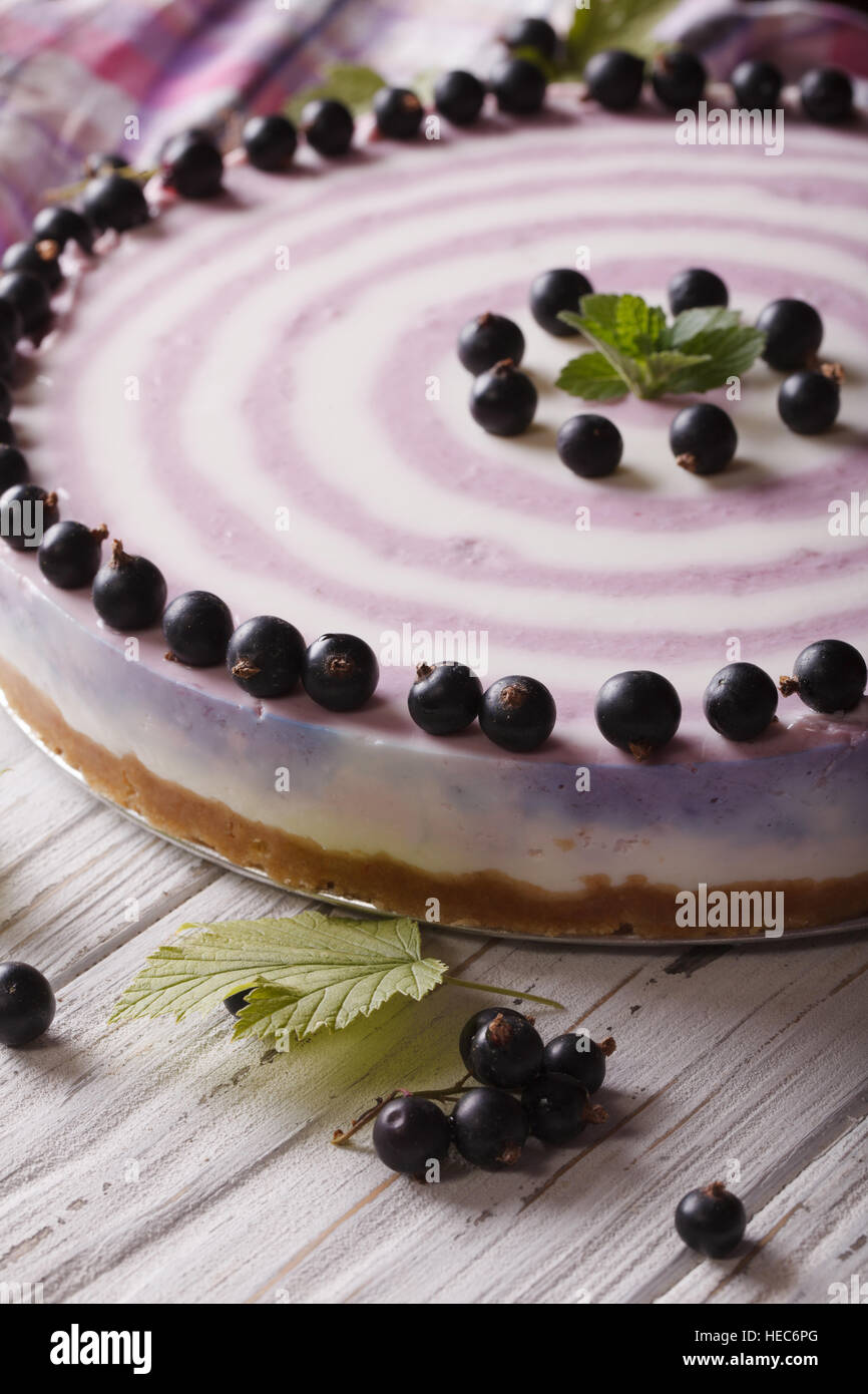 Beautiful striped currant cheesecake macro on a table. Vertical Stock Photo