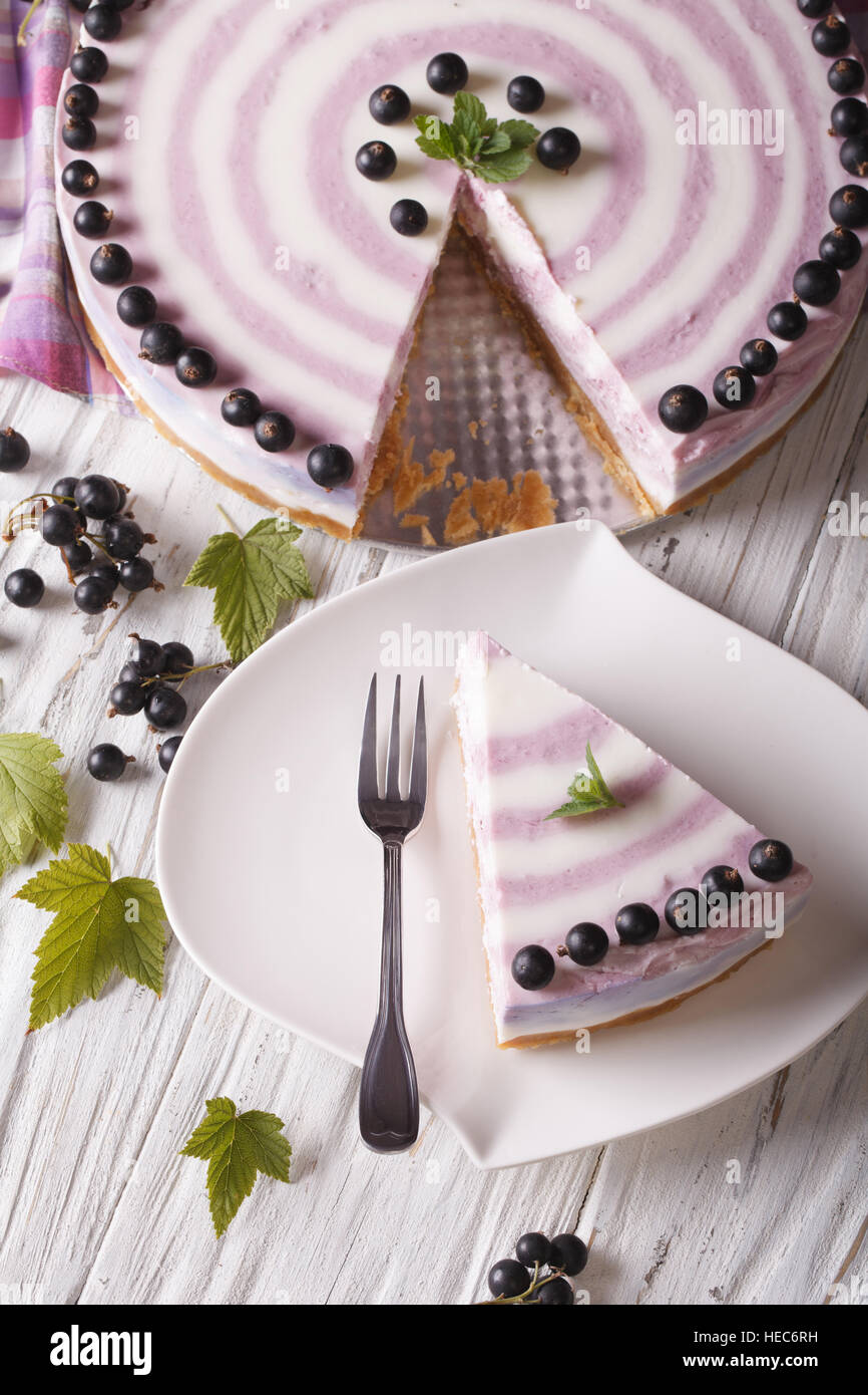 Beautiful sliced cheese cake with currants close-up on the table. vertical top view Stock Photo