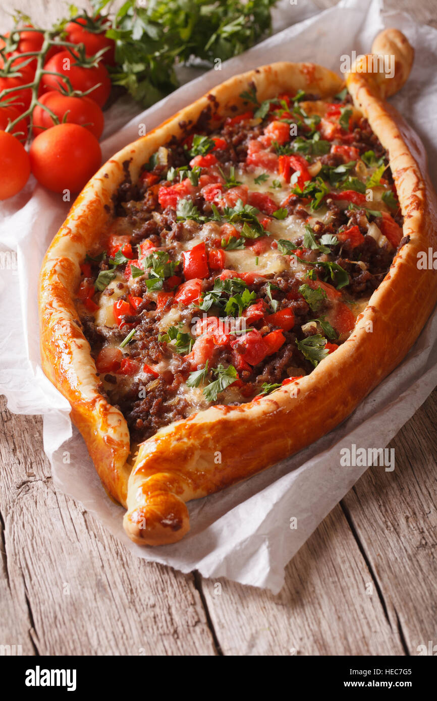 Turkish pide pizza with beef and vegetables close-up on the table. vertical Stock Photo