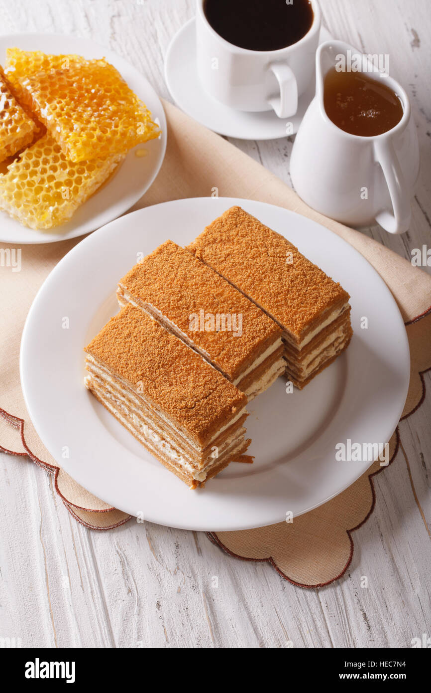 Sliced honey cake on a plate close-up and coffee. Vertical Stock Photo