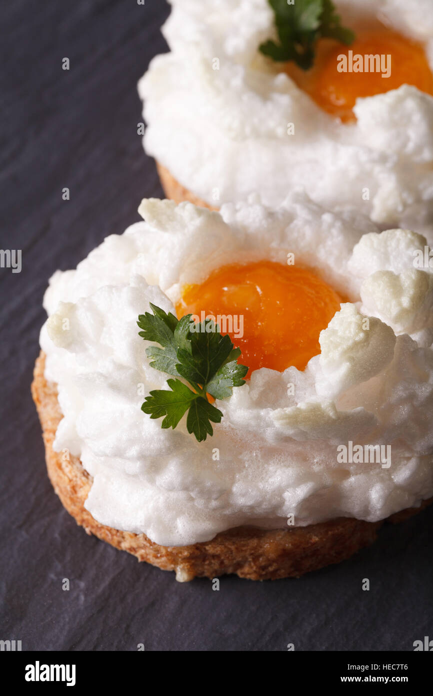 Eggs Orsini baked beaten egg whites and yolk on toast. Vertical close