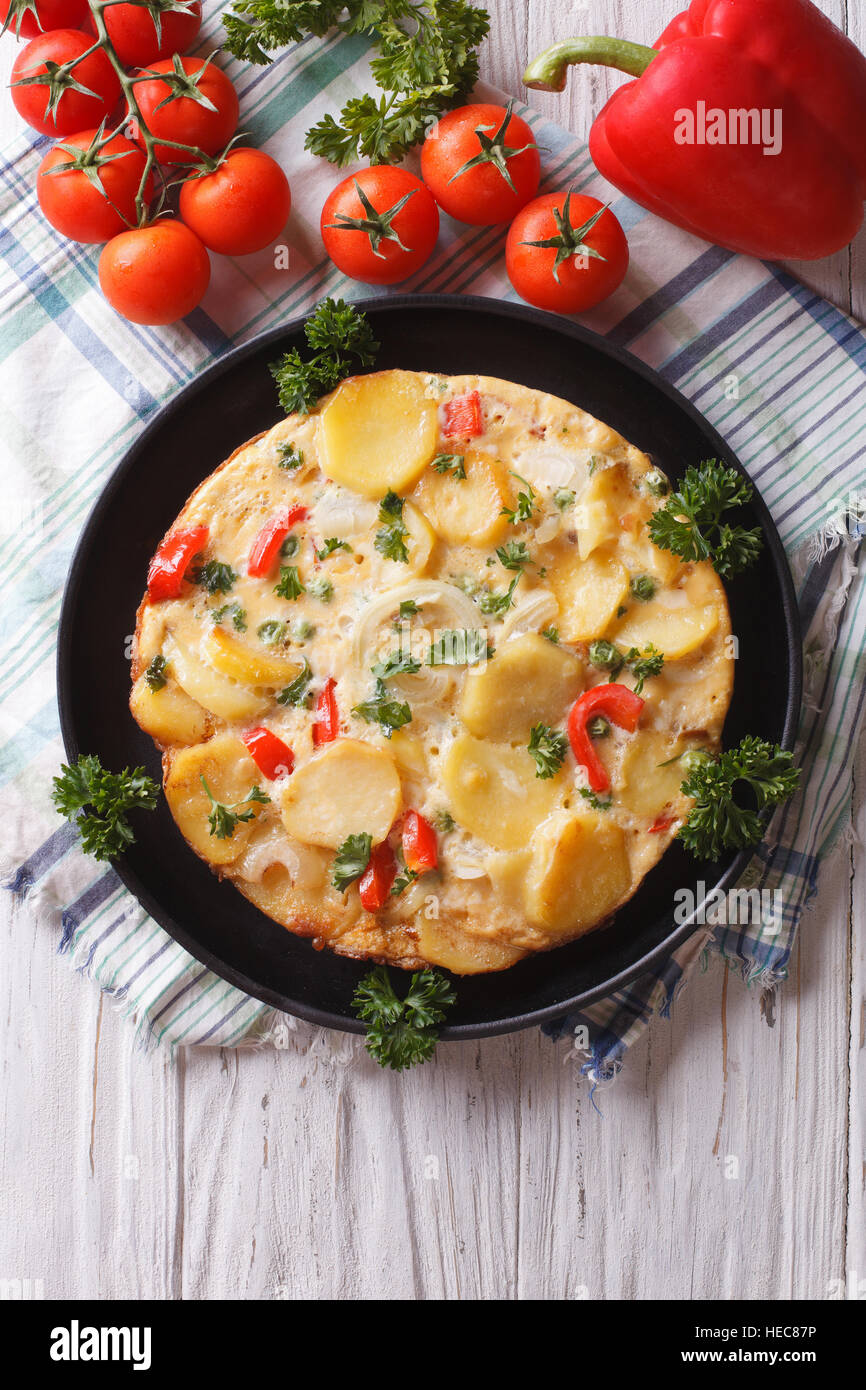 Delicious Spanish tortilla on a black frying pan close-up. vertical top view Stock Photo