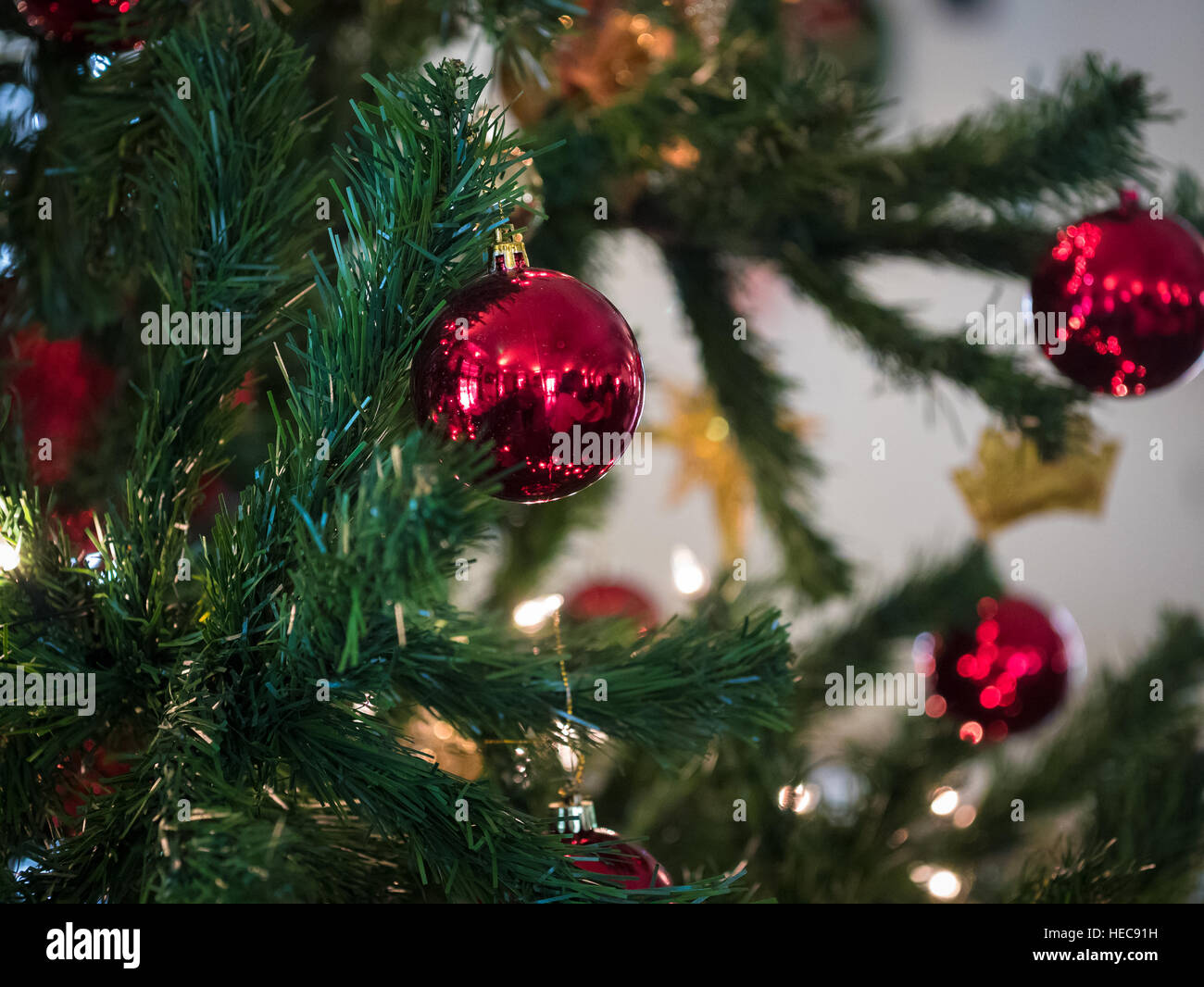 Closeup of red and silver ball hanging from a decorated Christmas tree Stock Photo