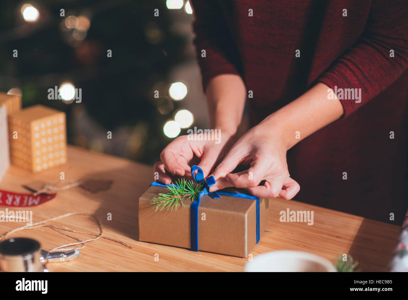 Woman Wrapping Christmas Present in Christmas setting Stock Photo