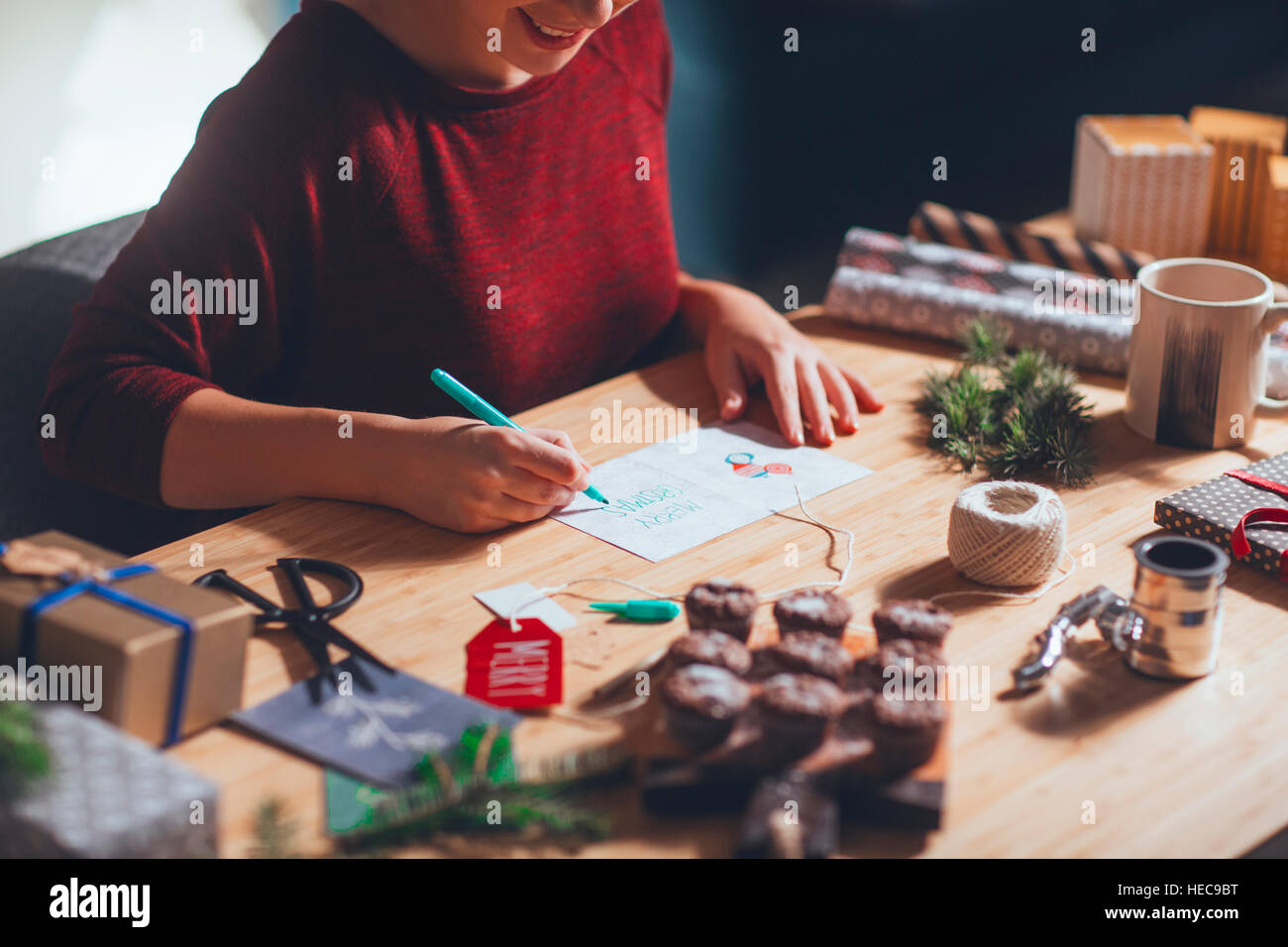 Woman writing Christmas card in Christmas setting Stock Photo
