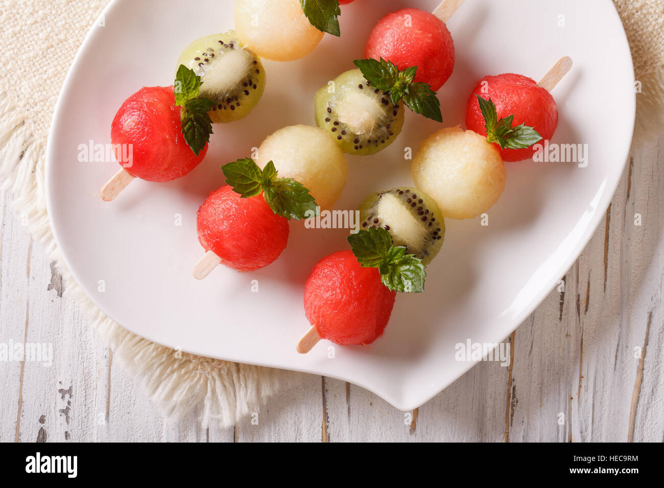 Fruit skewers with balls of watermelon, kiwi and melon closeup on a
