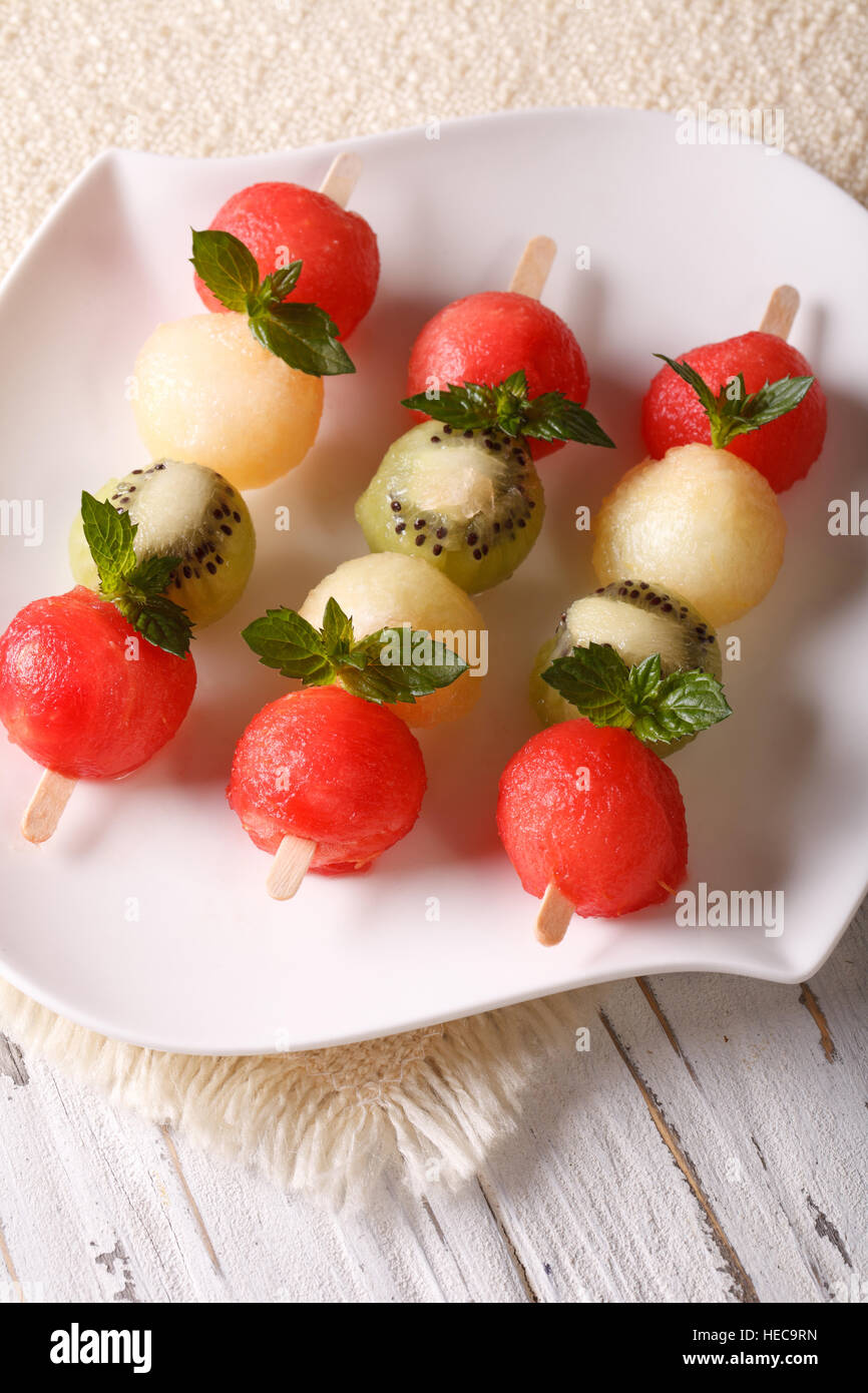Fruit skewers with balls of watermelon, kiwi and melon closeup on a