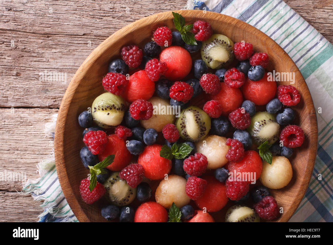 salad of blueberries, raspberries, melon and watermelon in a wooden bowl closeup. horizontal view from above Stock Photo