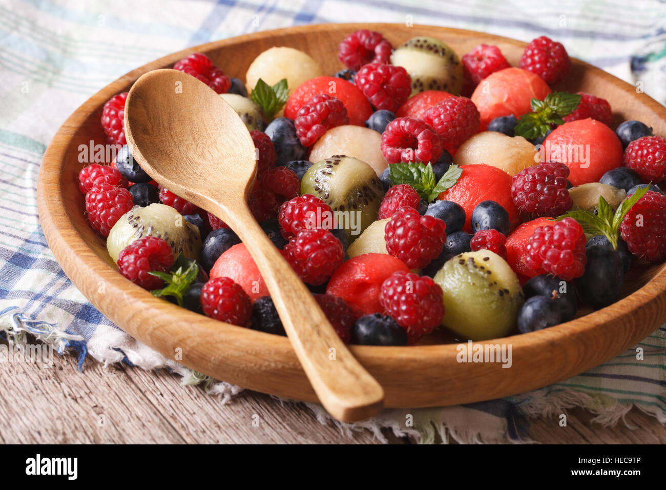fruit salad of blueberries, watermelon, raspberry, melon and kiwi in wooden bowl closeup. horizontal Stock Photo