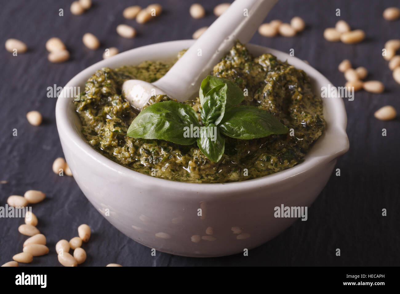 Italian green pesto sauce in a mortar close-up on the table. horizontal Stock Photo