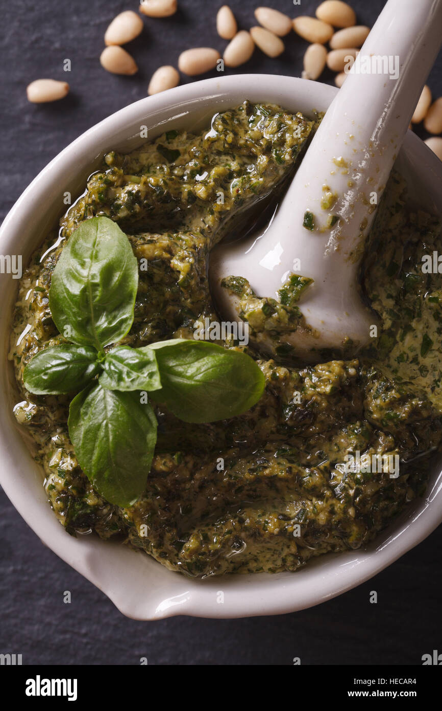Italian pesto sauce in a mortar macro. vertical top view Stock Photo