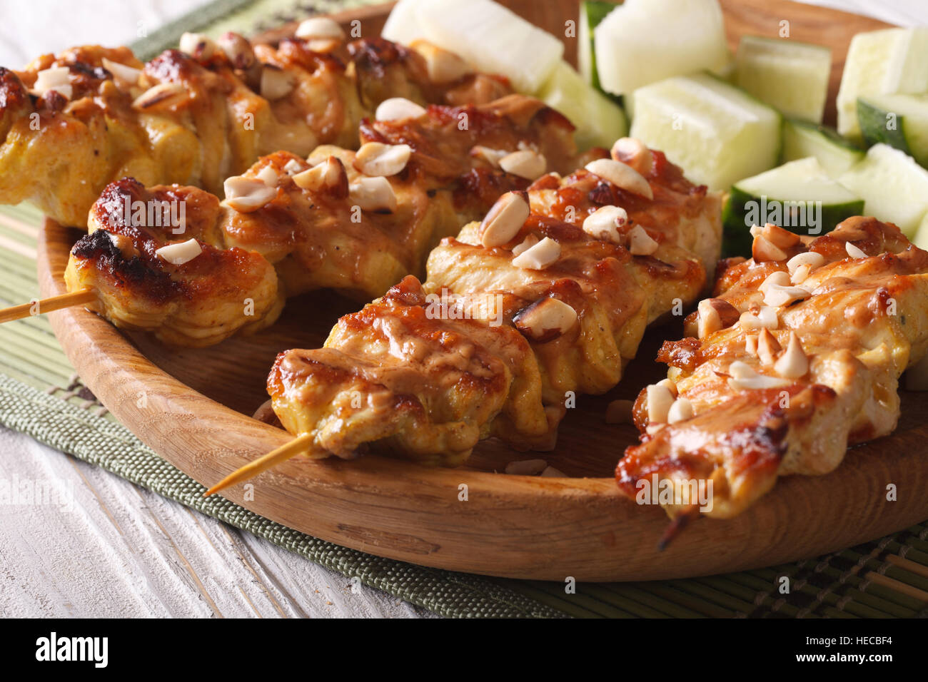 Asian Kebab Chicken satay sprinkled with roasted peanuts closeup on a