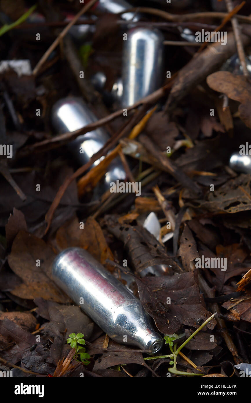 Used canisters of nitrous oxide lie on the ground Stock Photo