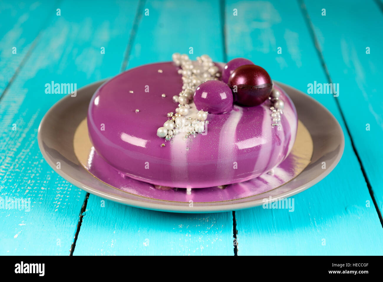 purple mousse cake with mirror glaze with blackberries, blueberries and coconut filling Stock Photo
