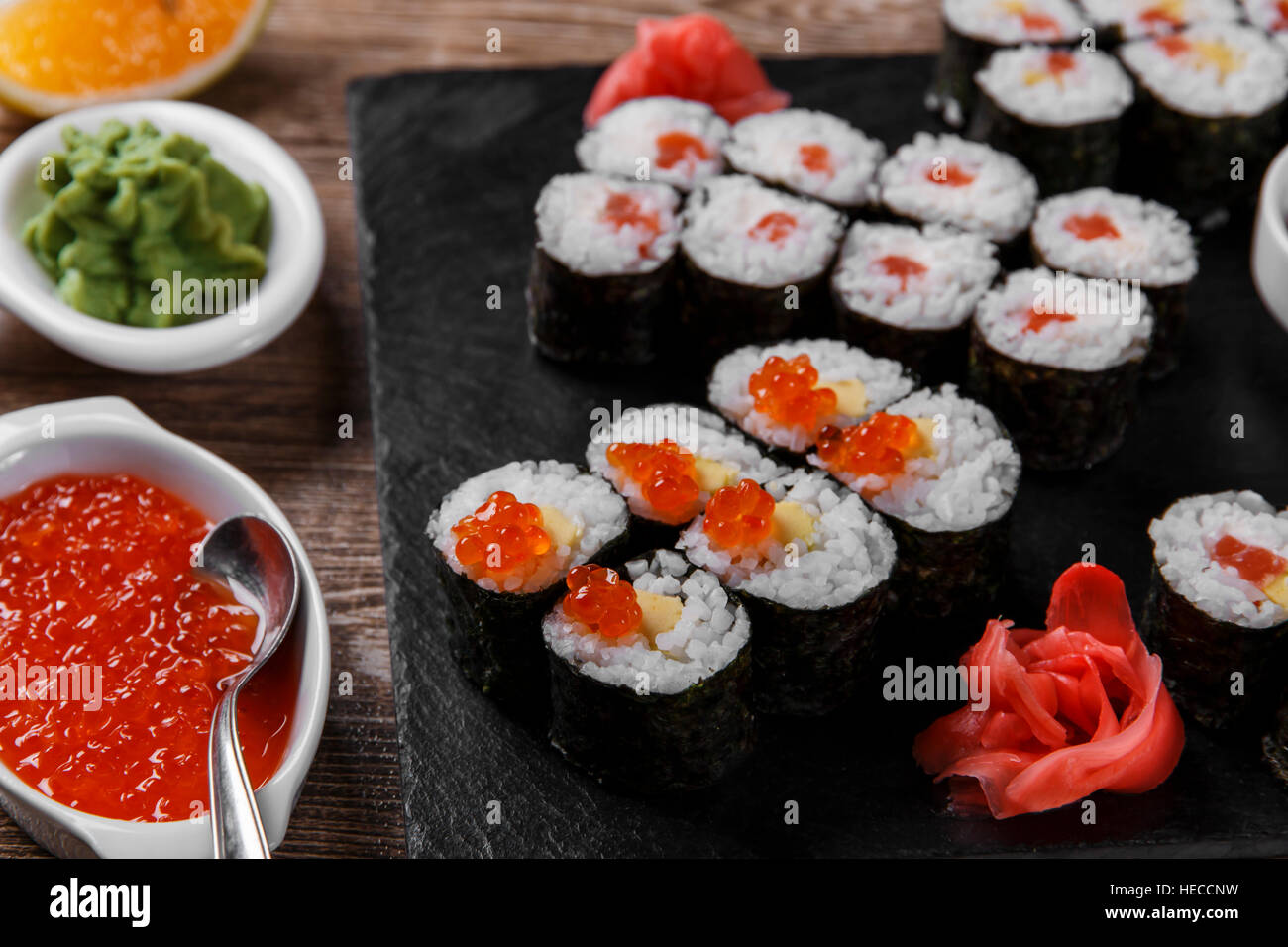 sushi rolls and ingredients served on a wooden surface Stock Photo