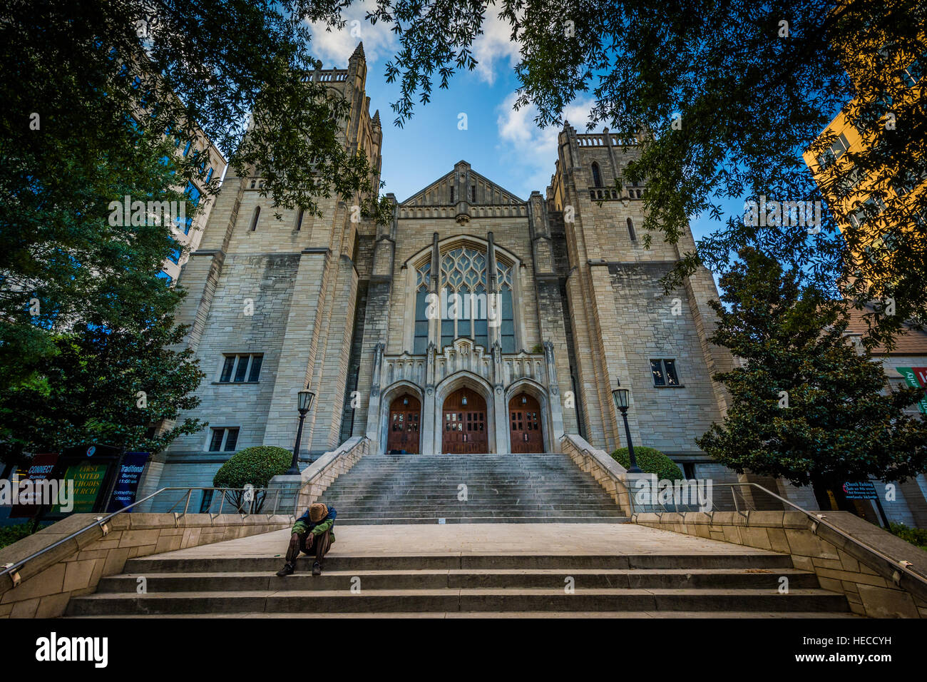 Man sitting on the steps of First United Methodist Church, in Uptown Charlotte, North Carolina. Stock Photo