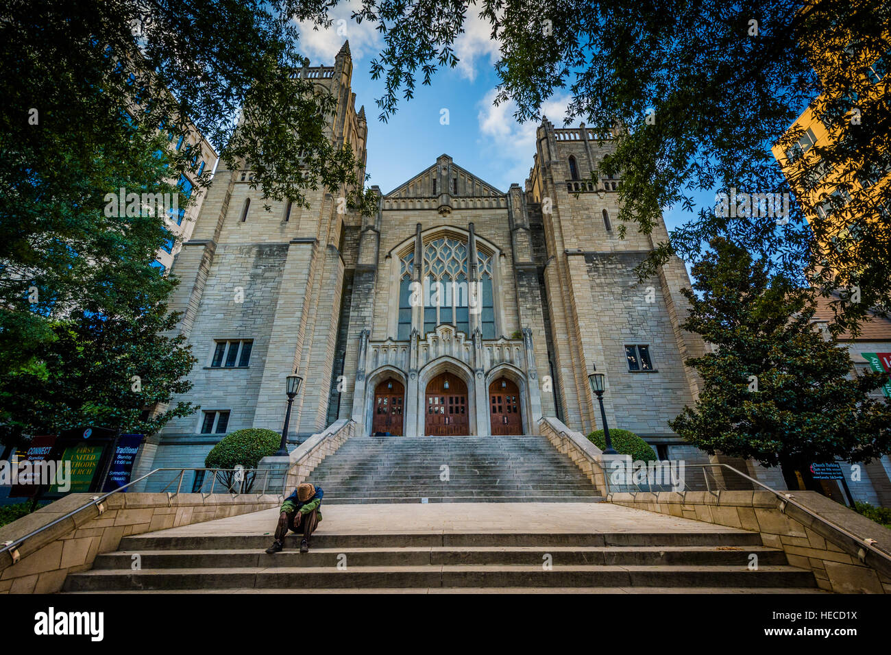 Man sitting on the steps of First United Methodist Church, in Uptown Charlotte, North Carolina. Stock Photo