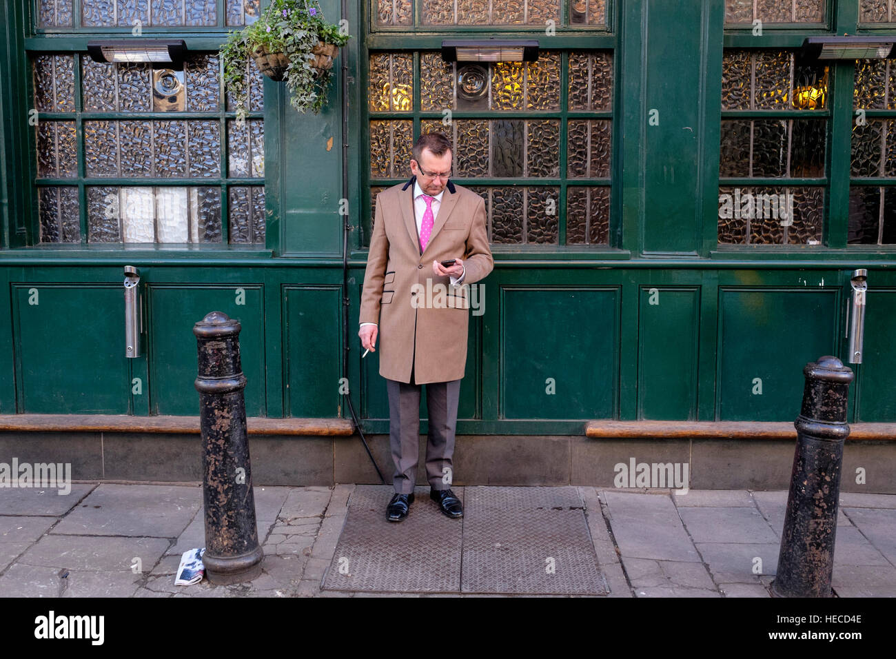 Businessman enjoys a cigarette outside a London pub Stock Photo