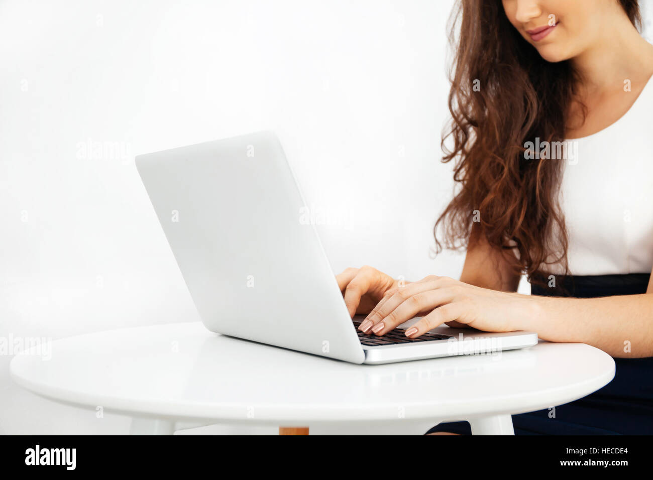 Beautiful Caucasian woman working on laptop on white desk over white isolated background with copy space Stock Photo