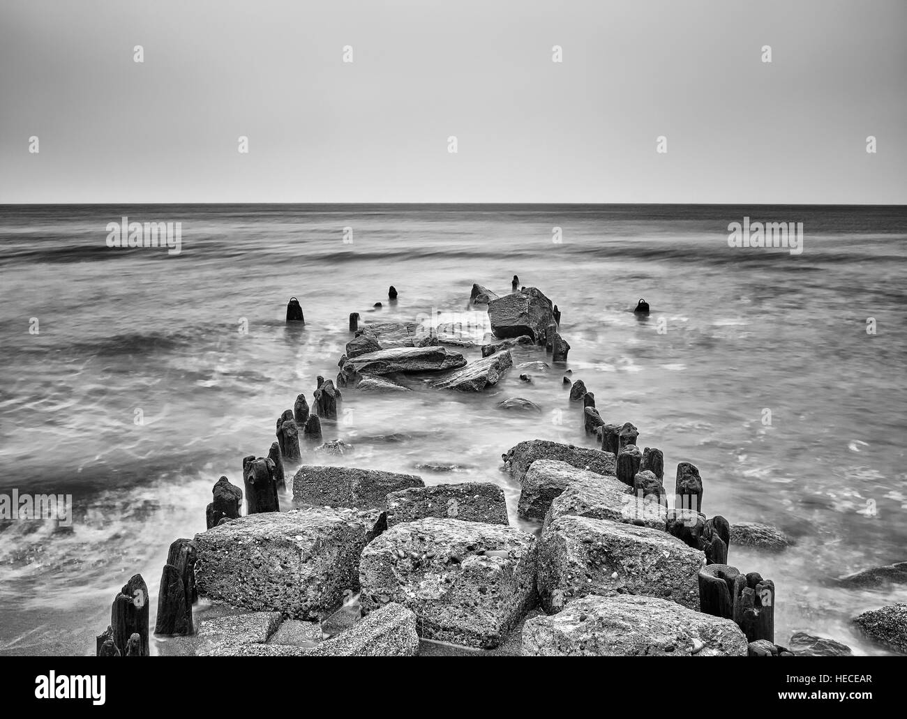 Black and white picture of an old breakwater on a beach, Baltic Sea coast, Poland. Stock Photo
