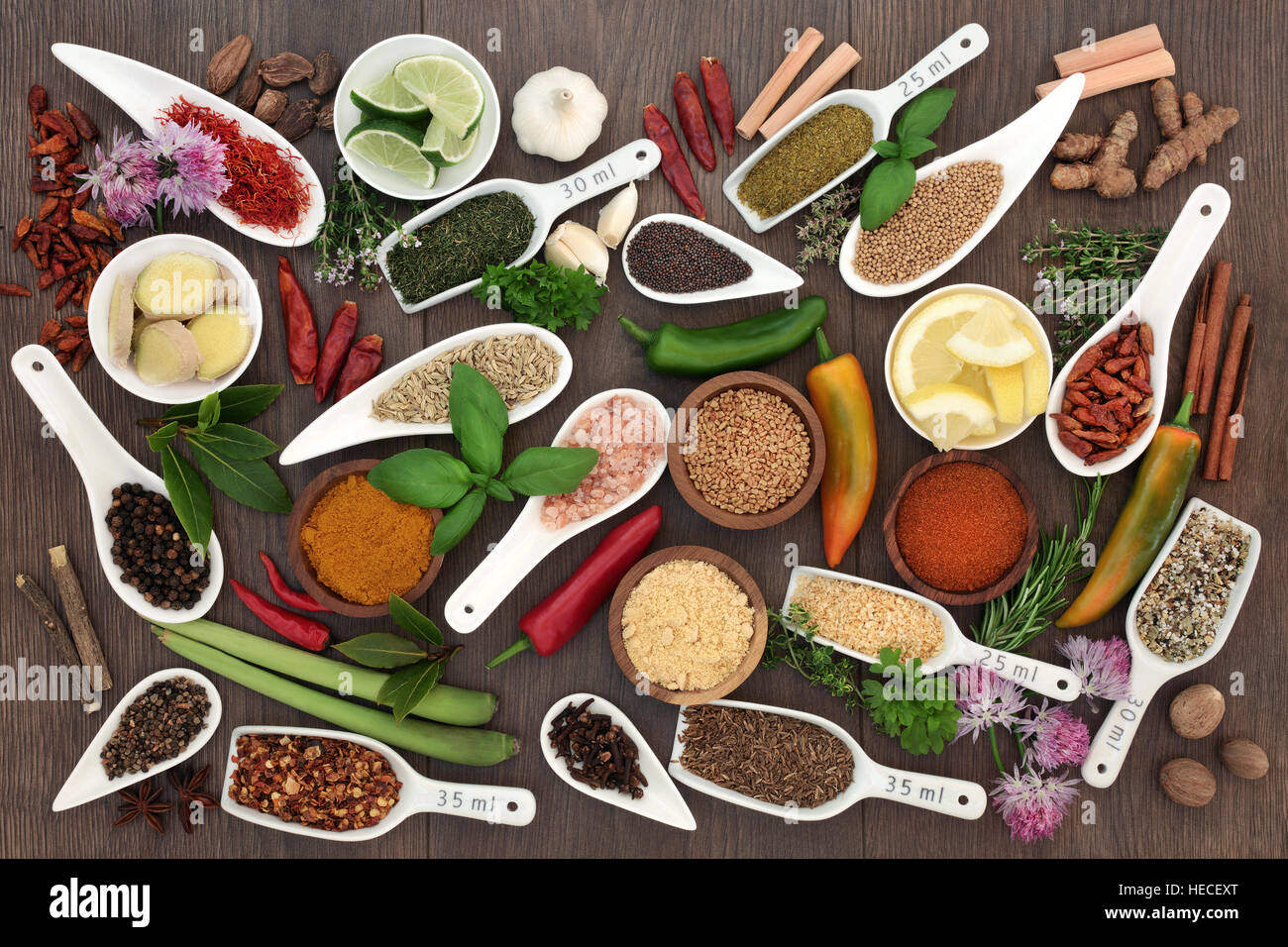 Spice and herb sampler with fresh and dried herbs and spices on oak
