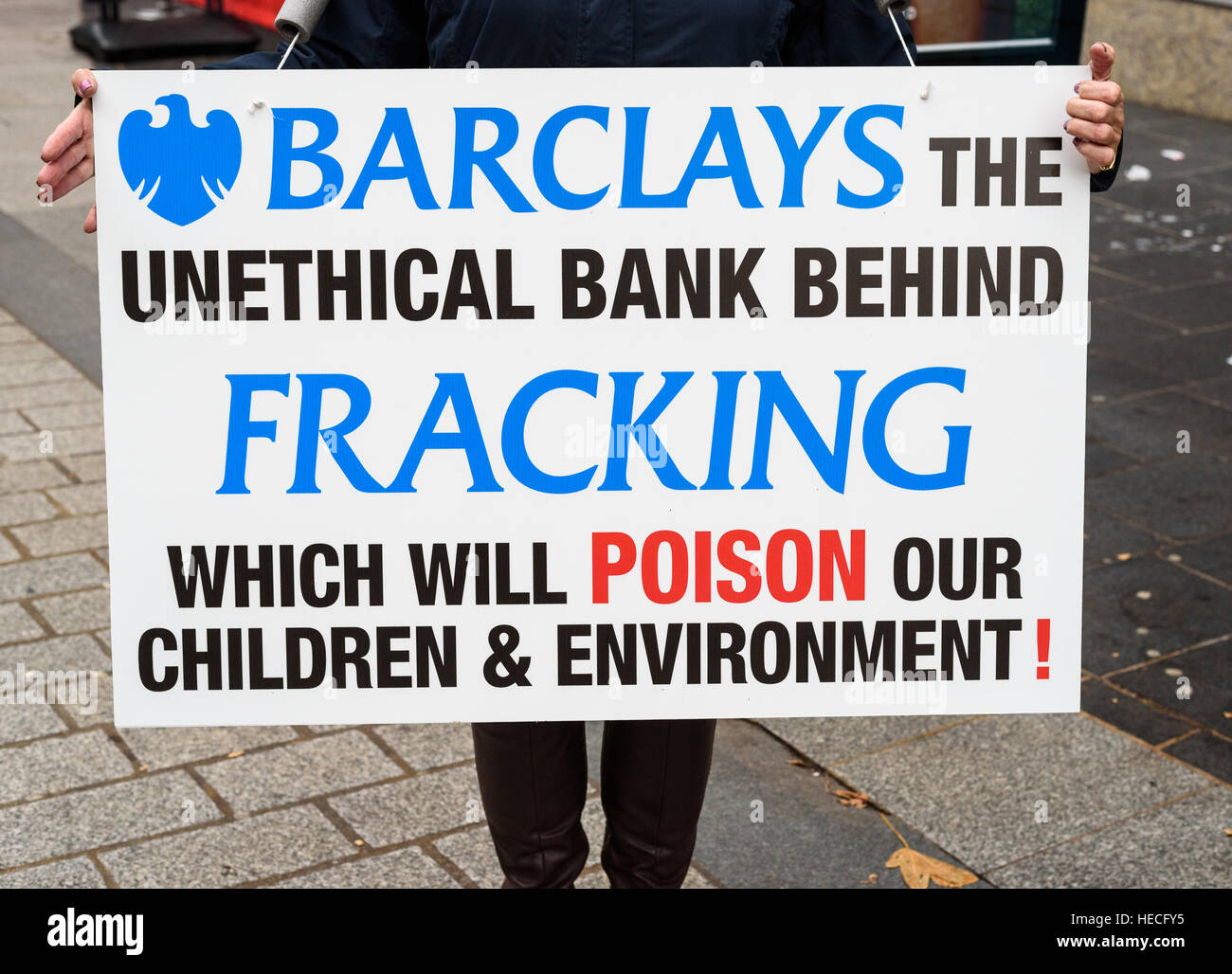Anti-fracking protest. Anti-fracking campaigner holding placard opposed to Barclays bank's fun Stock Photo