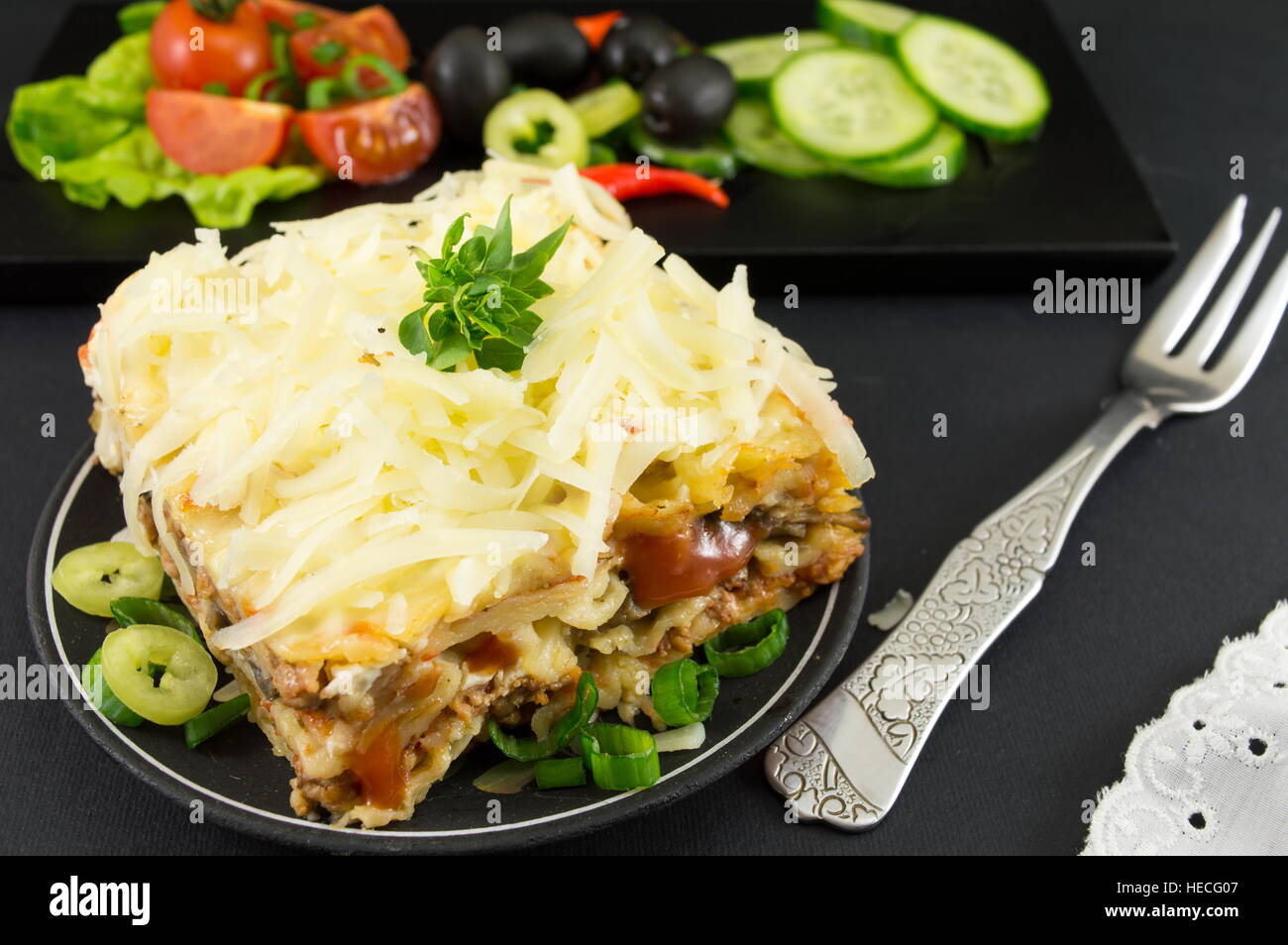 Portion of lasagna with vegetables on a dark table Stock Photo