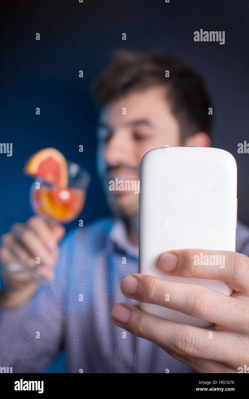 Crazy man making a selfie with a cocktail at the party Stock Photo