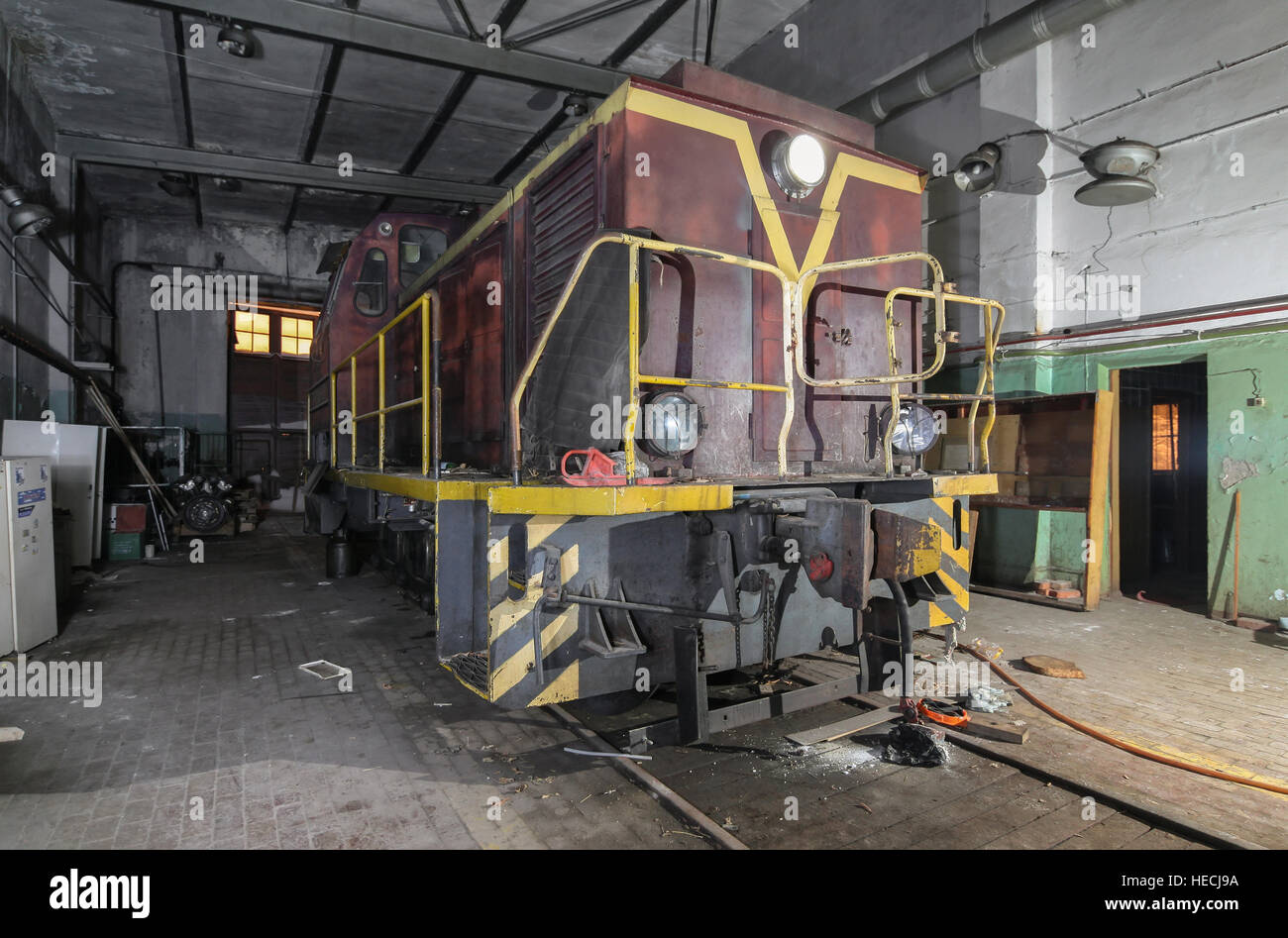 Old soviet shunting diesel locomotive in the abandoned room for servicing Stock Photo