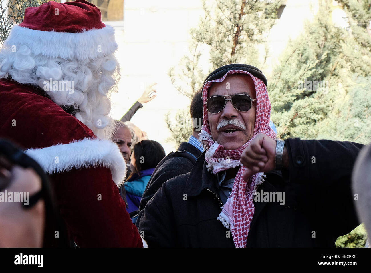 Jerusalem, Israel. 20th December, 2016. Santa Claus, or 'Baba Noel' as he is called in the local Arab language, greets a Muslim man at Jerusalem's Old City Jaffa Gate. The Jerusalem Municipality and the Jewish National Fund distributed specially grown Cyprus Cedar Christmas trees to the Christian population at the Jaffa Gate. Credit: Nir Alon/Alamy Live News Stock Photo