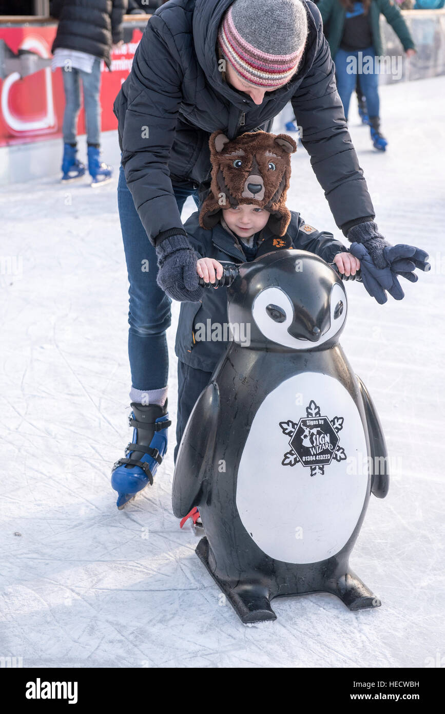Families and children having fun on outdoor ice skating rink