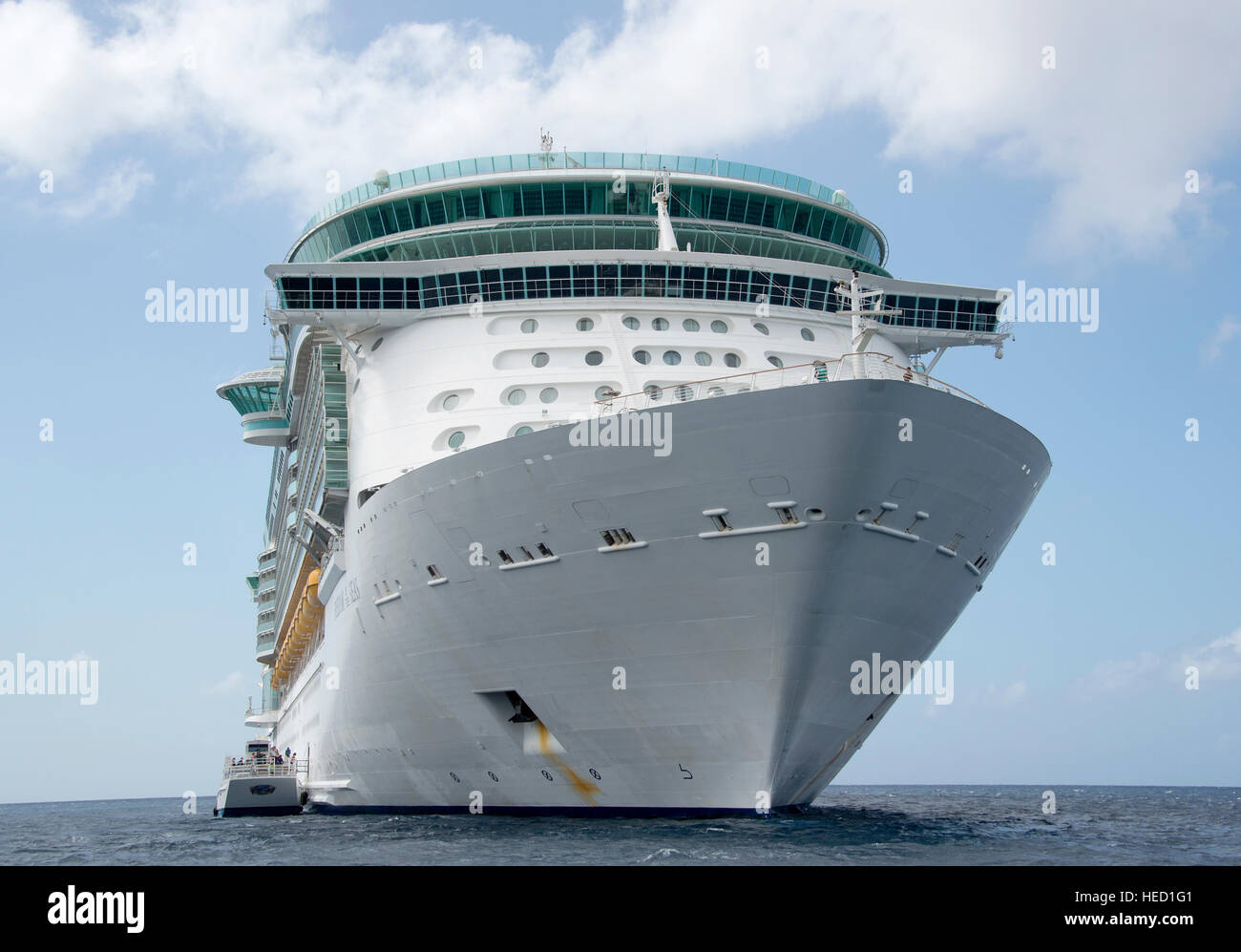 The Royal Caribbean Freedom of the Seas, which carries 4,515 passengers and 1,360 crew, and the Celebrity Reflection, which carries 3,609 passengers and 1271 crew, in the harbor of George Town, Grand Cayman in the Cayman Islands on Tuesday, December 20, 2016.  The smaller boat alongside the ship is a tender to ferry passengers back and forth to the island. Credit: Ron Sachs / CNP /MediaPunch Stock Photo