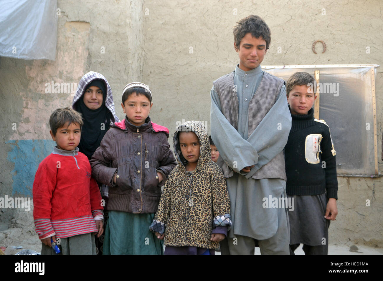 Six of Sang Bibi's children in the courtyard of her rented mud hut in the small internally displayed persons camp where she lives with a family of 9, on the outskirts of Kabul city, Afghanistan, 20 December 2016. She had to flee Kunduz after her 5-year-old daughter and husband were killed when a mortar landed on her house. Around 580,000 people have been displaced due to conflict related violence in 2016 alone, surprising the Afghan government and international community alike. Photo: Mohammad Jawad/dpa Stock Photo