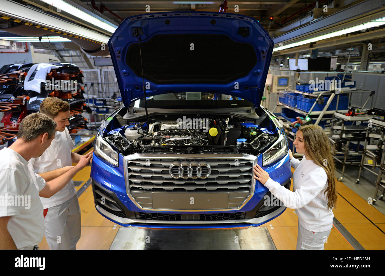 Ingolstadt, Germany. 15th Dec, 2016. Trainees David Lubojanski (3rd year production mechanic) and Dilara Ekinci (2nd year production mechanic) can be seen attaching the front end piece to an Audi on an assembly line at the Audi factory in Ingolstadt, Germany, 15 December 2016. Photo: Andreas Gebert/dpa/Alamy Live News Stock Photo