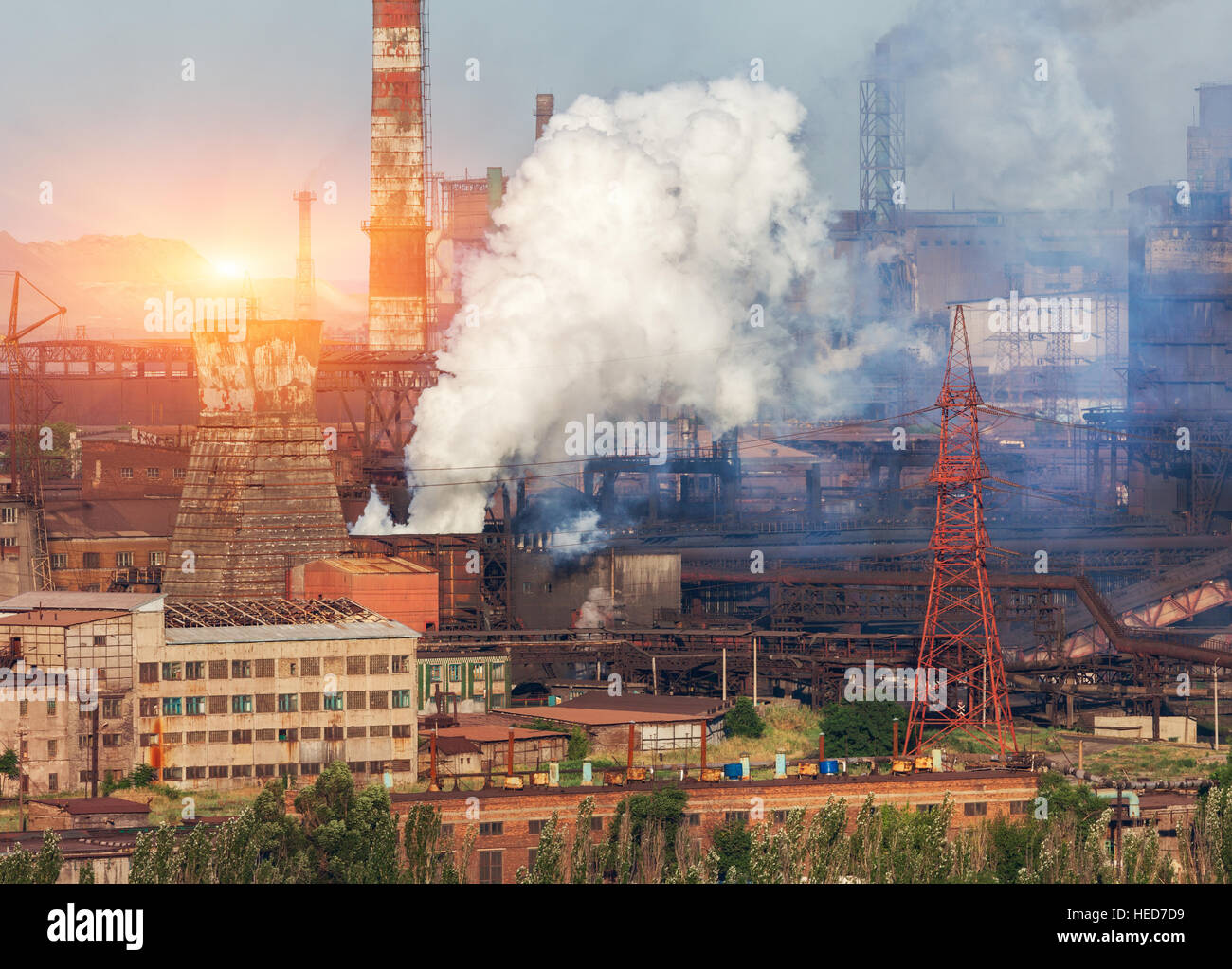 Metallurgy plant in Ukraine at sunset. Steel factory with smog. Pipes with smoke. Steel mill. Heavy industry factory. Plant Stock Photo