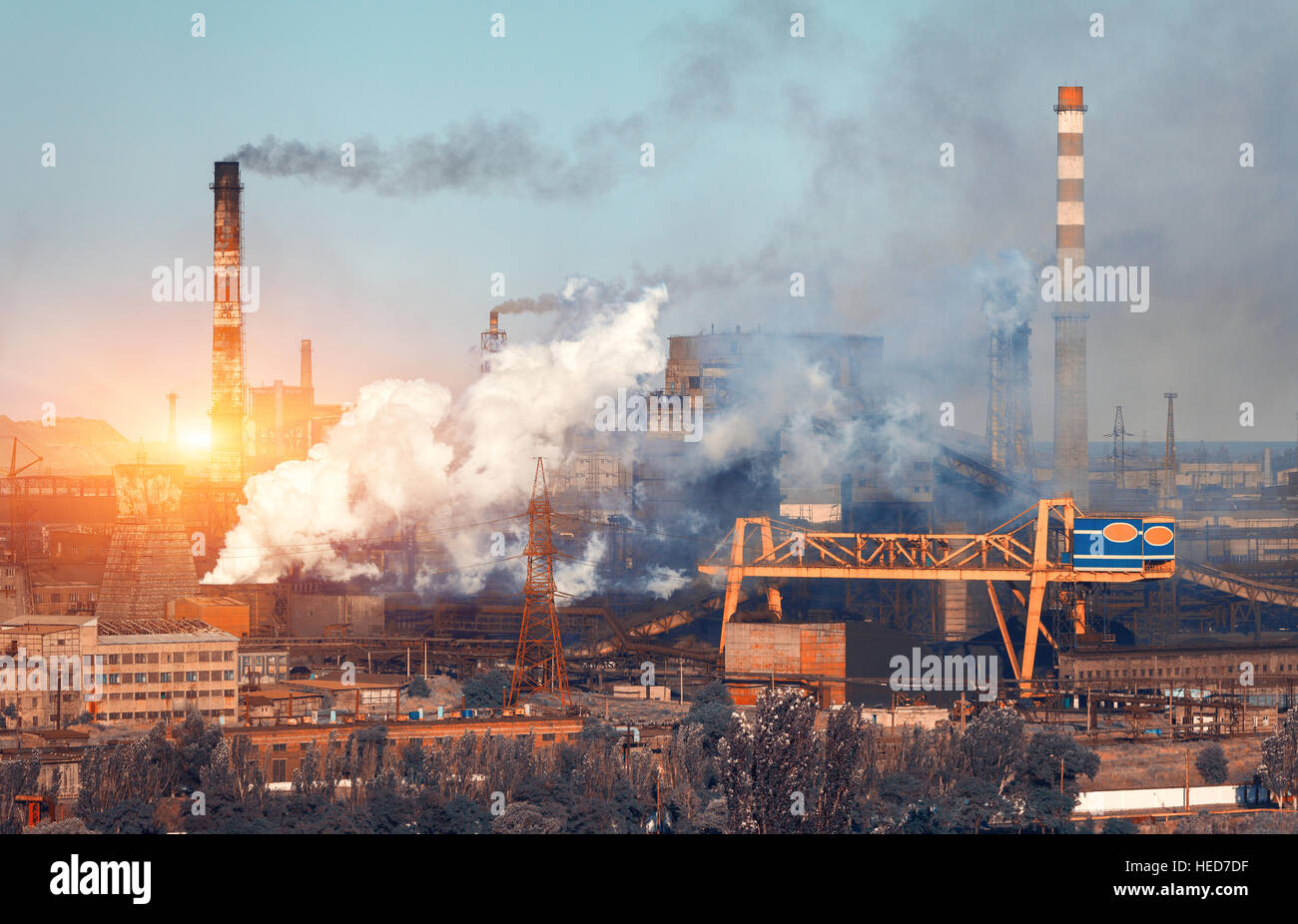 Metallurgy plant in Ukraine at sunset. Steel factory with smog. Pipes with smoke. Steel mill. Heavy industry factory. Plant Stock Photo